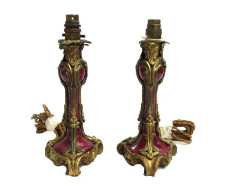 A pair of French porcelain and ormolu mounted table lamps (converted), late 19th century, foliate cast open frame encasing a 