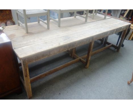 A 20th century oak laboratory bench with triple plank top on six square supports united by stretcher, 259cm wide x 77cm high 