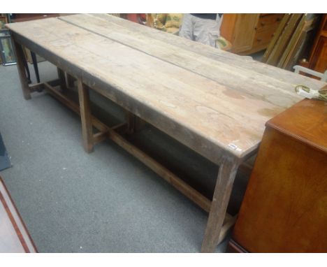 A 20th century oak laboratory bench with triple plank top, on six square supports, united by stretcher, 259cm wide x 77cm hig