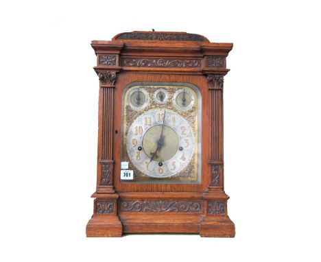 A German oak cased bracket clock, early 20th century, the carved breakfront case enclosing a W&S three train movement chiming