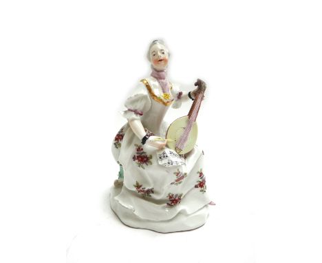 A Vienna figure of a lady playing a mandolin, circa 1770, blue shield mark, modelled with sheet music on her knee, on a natur