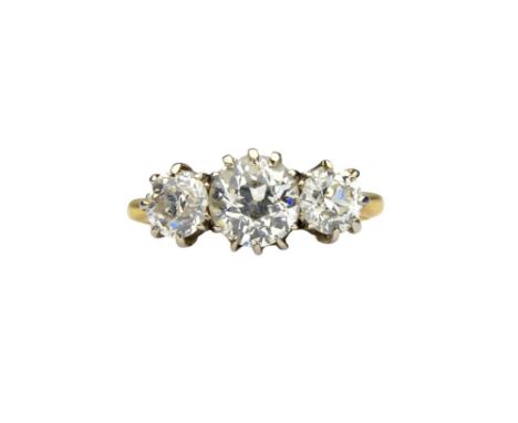 A gold and diamond set three stone ring, claw set with a row of cushion shaped diamonds and with the principle diamond mounte