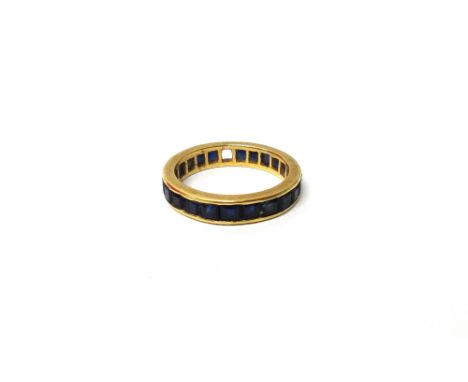 A gold and sapphire set full eternity ring, mounted with calibre cut sapphires (one sapphire lacking), ring size P and a half