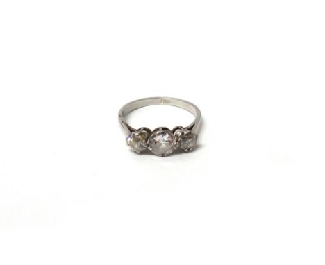 A diamond set three stone ring, claw set with a row of cushion shaped diamonds and with the principal diamond mounted at the 