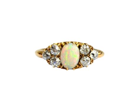 An 18ct gold, opal and diamond ring, mounted with the oval opal at the centre, between diamond set three stone sides, mounted