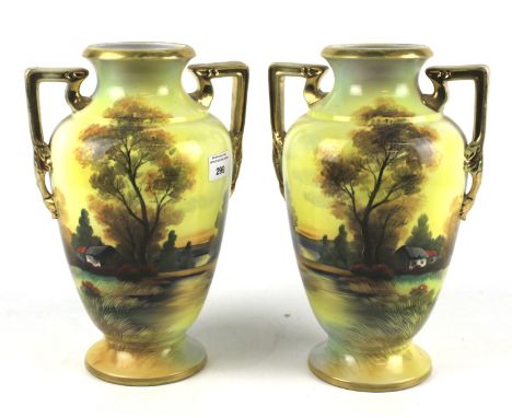A pair of 20th century Noritake porcelain vases. Decorated with country scenes by a lake, twin handled, H29cm Condition Repor
