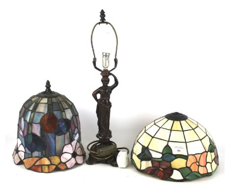 Two Tiffany style leaded glass lampshades. Both decorated with flowers, together with a cast metal lamp base modelled as a Gr