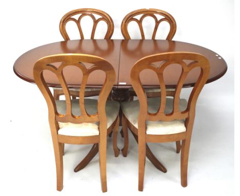 A contemporary wooden extendable dining table and four chairs. The table with a turned column and tripod supports, L147cm x D