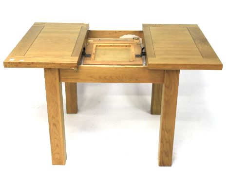 A modern oak extending dining table. With additional leaf to inside, raised upon square supports, L90cm x D90cm x H78cm Condi