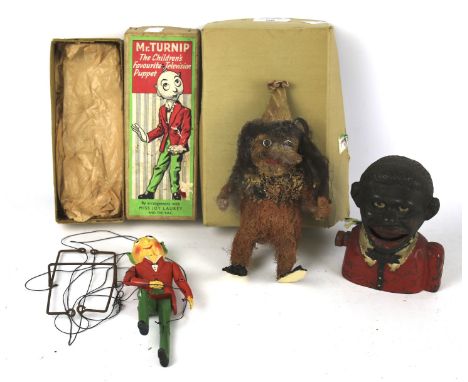 An assortment of collectables. To include a cast iron 'little Joe' money bank, Mr Turnip hand puppet in original box, etc