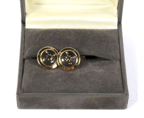 A pair of Christian Dior compass cufflinks. Each yellow metal cufflink stamped Dior C with black pebble pattern centre mounte