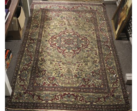 A 20th century woven rug. The central panel featuring a floral medallion surrounded by birds and foliage, on a brown ground i