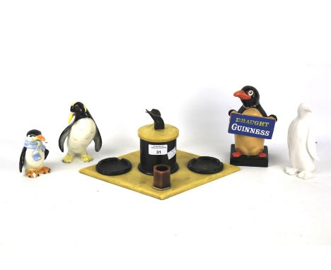 An assortment of penguin figures and novelties. Including a Bakelite tobacco stand, a 'Guinness' penguin and a Wedgwood ceram