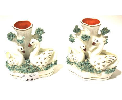 A pair of Staffordshire swan vases. Modelled as two swans beside a tree trunk, H12cm