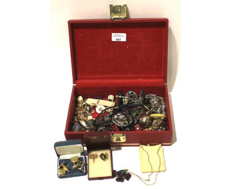 An assortment of costume jewellery. Including brooches, rings, cufflinks, etc, in a red leather jewellery box