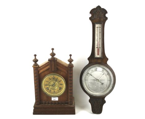 A contemporary mantel clock and a 19th century banjo barometer. The barometer in a wooden case with a thermometer to the top,