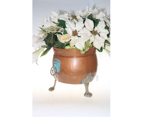Ornate copper and brass three foot planter with lion handle decoration, 34cm high.