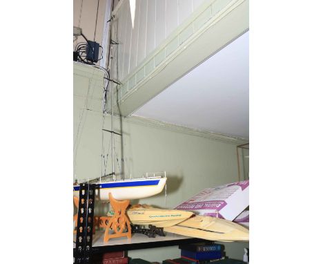 Three model sailing boats and a box of remote controls.