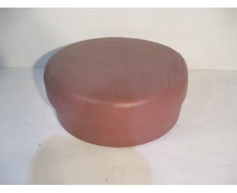 A large circular leather effect pouffe