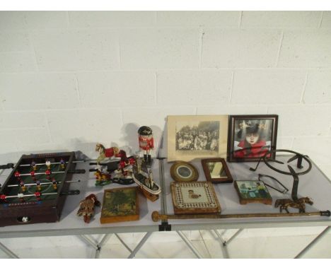 A collection of assorted items including a trivet, rocking horses, vintage photographs, walking stick, table football etc