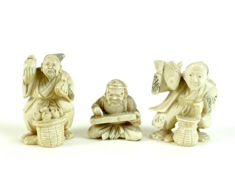 A group of three Japanese ivory katabori netsuke, Meiji period, comprising a pair of vendors, one with a basket of fruit, hol