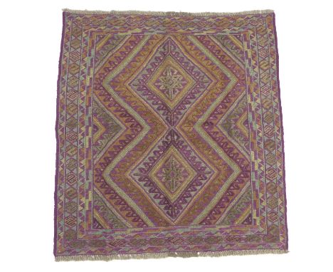 A Gazak rug, with orange, purple and light green double diamond shaped decoration, latch hook edges, 121 by 115cm. 