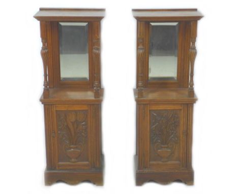 A pair of late 19th / early 20th century French oak cabinets, each with a top shelf with bevelled mirror plate backs and spir