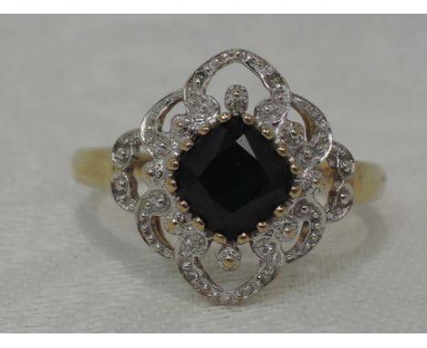 A lady's dress ring having a central sapphire in an open diamond chip set illusionary decorative surround on a 9ct gold loop,