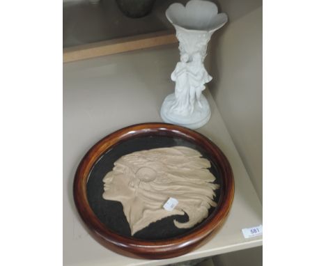 A vintage circular plaque portraying Native American Indian, in frame, and a bisque vase portraying lovers