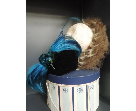 A vintage hat of cream and beige features and a vintage hat box