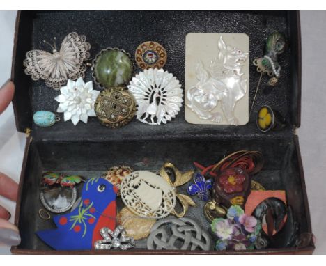 A vintage leather box containing a selection of brooches including filligree and mother of pearl