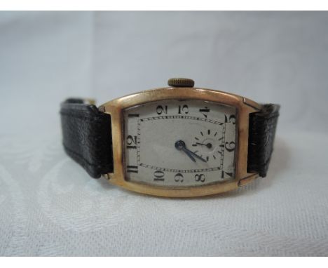 A gents vintage 9ct rose gold wrist watch having Arabic numeral dial with subsidiary seconds to a rectangular face on a black
