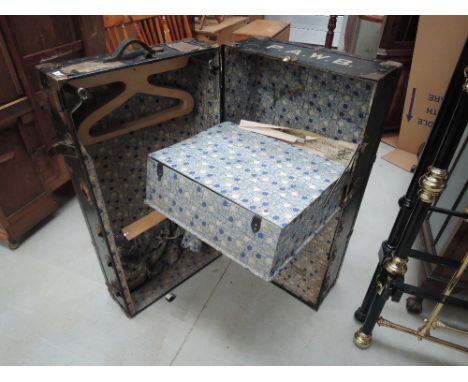 A late Victorian/Edwardian travel trunk having brass applique and piper levels with fitted valise interior