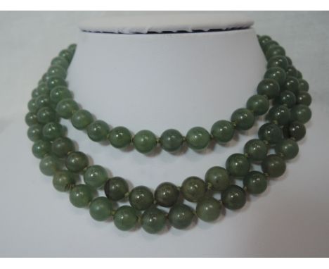 A three strand jadeite bead necklace of even form having an oval white metal and jade box clasp