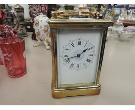 An early 20th century brass carriage clock of traditional French design, having enamel face with blue detail