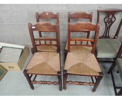 A set of four early 19th century beech vernacular kitchen chairs having bobbin rail backs, with later rush seats and turned l