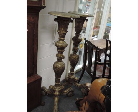 A pair of 19th century gilt wood and gesso torchere stands in the ornate Baroque style having foliate decoration and vintage 