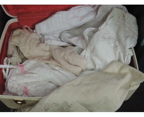 Vintage suitcase containing various vintage and antique items, including two early 20th century nightdresses and a petticoat.