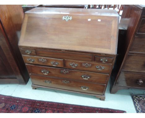 An early 19th century part mahogany bureau having slope front with fitted interior, drawer base and bracket feet