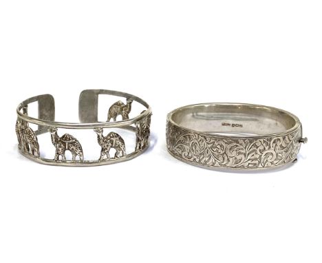 An early 20th century silver bangle with foliate engraved detail, hallmarked for Birmingham 1940, 24.6g; together with a whit