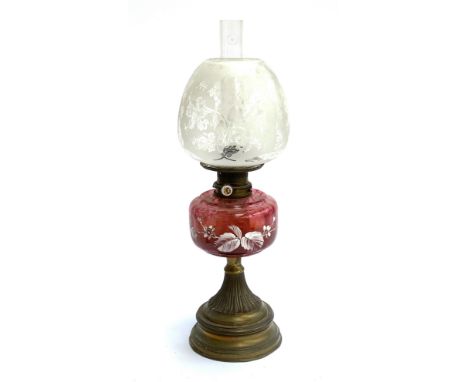 A large oil lamp with Mary Gregory style cranberry glass reservoir, and etched glass shade