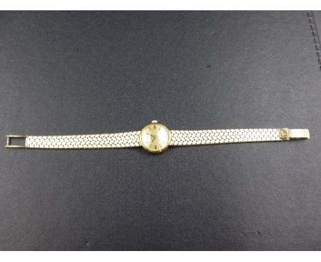 A LADIES GOLD OMEGA WRIST WATCH, STAMPED 585 AND TESTED AS 14ct. ON A BRICK STYLE BRACELET WITH A LADDER CLASP. LENGTH 17cms,