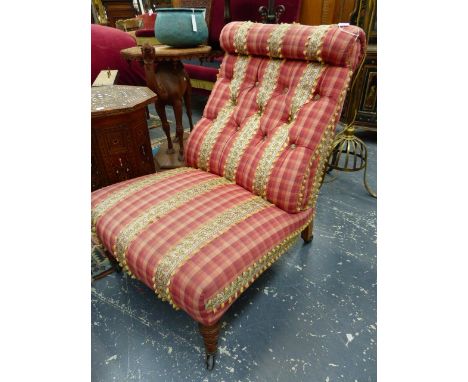 A VICTORIAN BUTTON UPHOLSTERED NURSING CHAIR ON TURNED FORELEGS WITH CERAMIC CASTORS, LATER RED CHECK FABRIC.