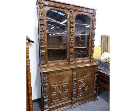 A 19th.C.CARVED OAK BOOKCASE WITH GLAZED UPPER SECTION OVER TWO GEOMETRIC CARVED PANEL DOORS.   W.137 x H.227 cms