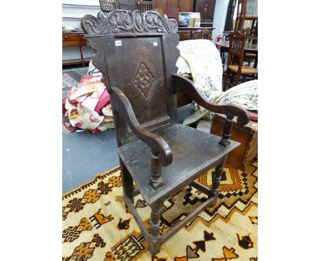 AN 18th.C.OAK WAINSCOTT CHAIR WITH CARVED BACK PANEL AND SHAPED ARMS.H. (AT BACK) 102cms, SEAT H.50cms.