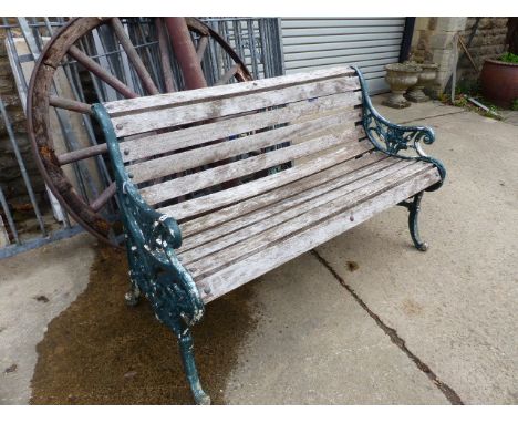 A VICTORIAN AND LATER PAINTED GREEN CAST IRON GARDEN BENCH.