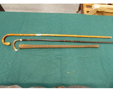 AN ORIENTAL BAMBOO WALKING CANE CARVED WITH RATS AND A HORN  HANDLE, A LEATHER SHAFT WALKING STICK AND AN AFRICAN HARDWOOD SH