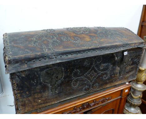 AN EARLY NAILED AND STUDDED LEATHER COVERED DOME TOP TRUNK WITH CARRYING HANDLES.   W.107cms.
