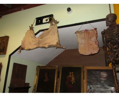 HORROR FILM PROPS. A WELL CAST RUBBERISED RESIN MODEL OF A CORPSE IN SEATED POSE TOGETHER WITH TWO BLOODIED SKIN BANNERS.