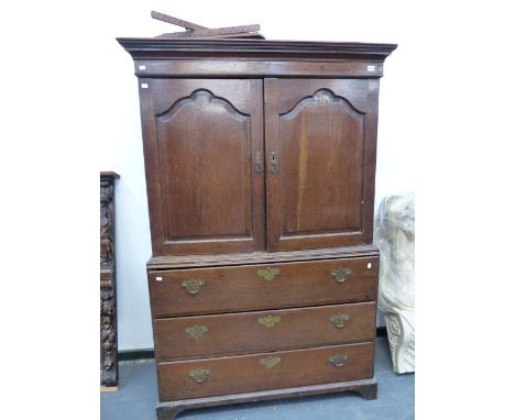 AN 18th.C.AND LATER OAK SECRETAIRE LINEN PRESS WITH A PAIR OF SHAPED PANEL DOORS OVER FALL FRONT DRAWER AND TWO DEEP DRAWERS 